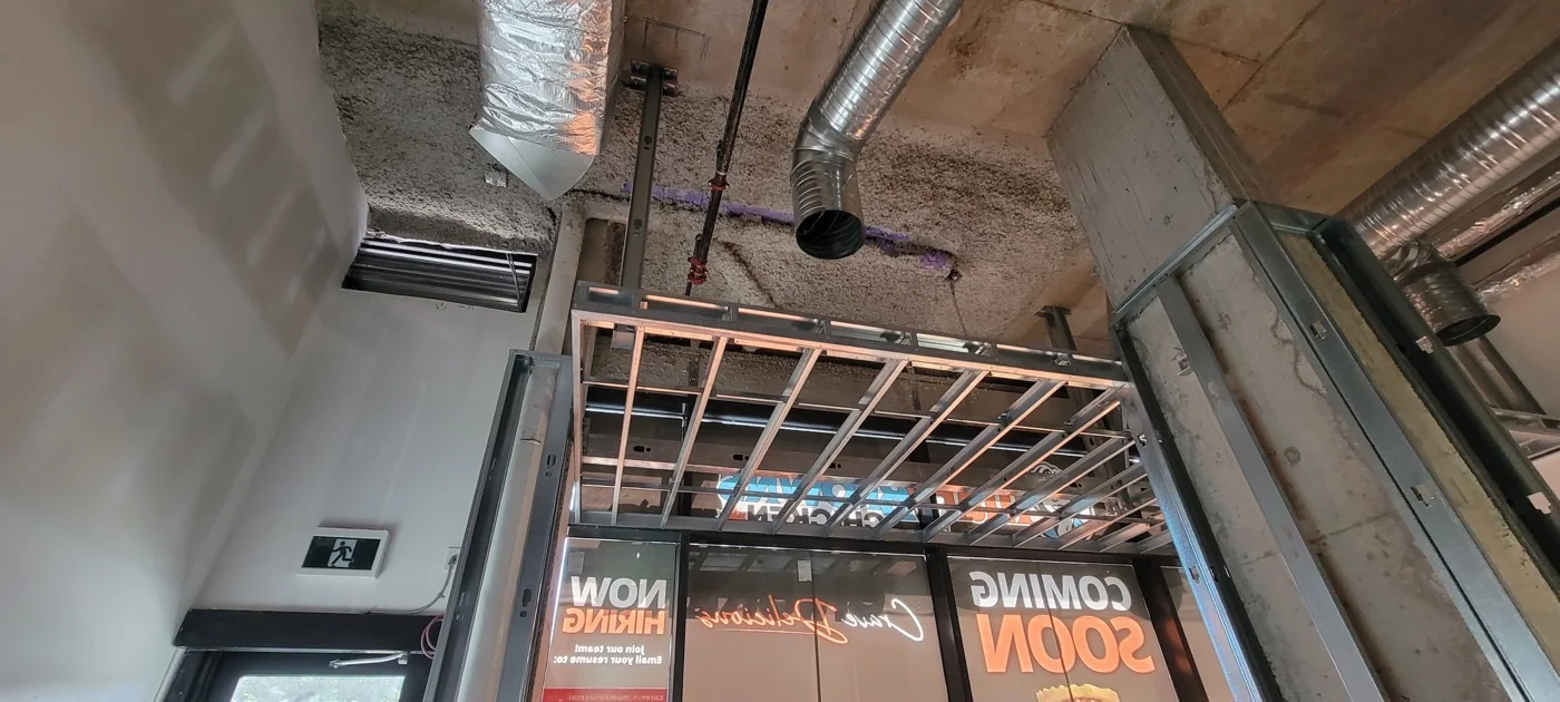 Commercial ceiling framing and curved bulkhead work in progress — project photograph supplied by Mason McKenzie / Rambo